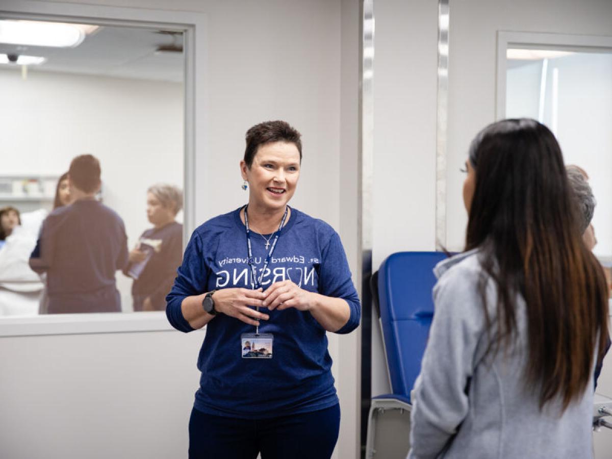 Donna Beuk talks to a student in the nursing labs