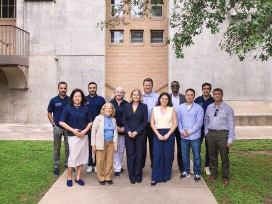 Business faculty and staff stand outside of The Bill Munday School of Business.